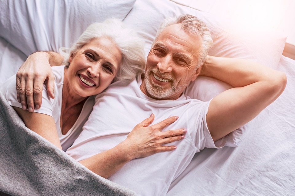 Pareja en la cama  Hablando y riendo